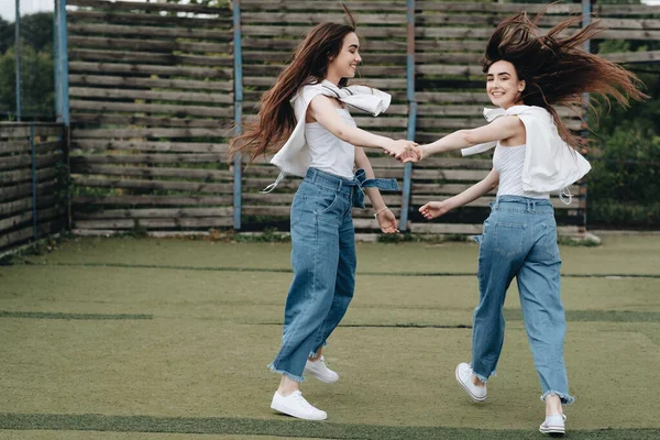 Portret dwóch młodych sióstr Brunetki ubranych jak w dżinsach i białej koszulce, koncepcja Best Friends Forever — Zdjęcie stockowe