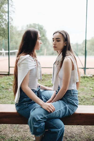 Retrato de duas jovens gêmeas morena irmãs vestidas de jeans e camiseta branca, Melhores amigos sempre conceito — Fotografia de Stock