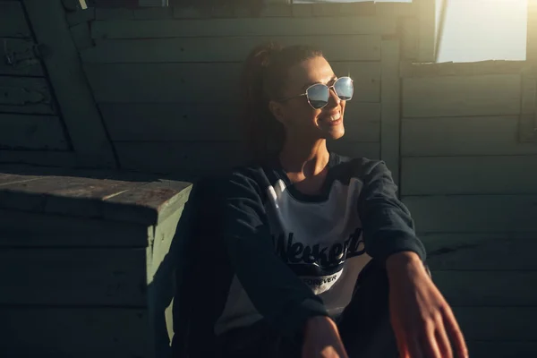 Schöne junge Hipster-Mädchen im Pullover mit dem Text "Wochenende für immer" am Strand bei Sonnenuntergang — Stockfoto