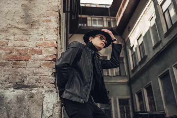 Retrato de jovem elegante em jaqueta de couro preto e chapéu — Fotografia de Stock