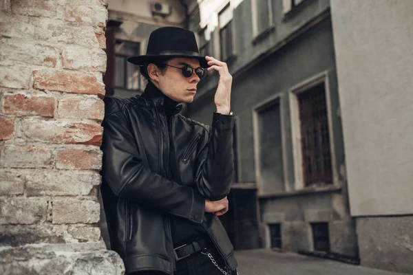 Portrait de jeune homme élégant en veste et chapeau en cuir noir — Photo