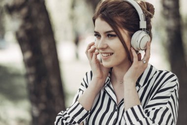 Beyaz Çizgili Şık Elbiseli Genç Güzel Kızın Açık Yaz Portresi Kulaklıkla Müzik Dinliyor