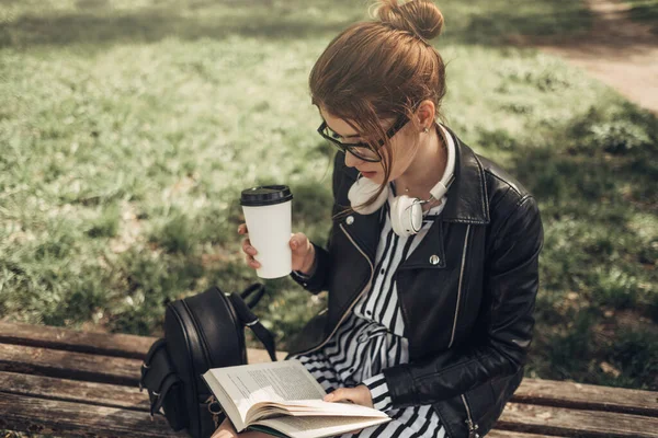 Outdoor Summer Portrait of Young Beautiful Girl in Black Leather Jacket Leads Livro no Parque — Fotografia de Stock