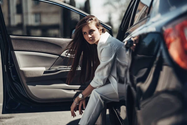Divat stílusos lány fehér öltönyt jelentő közelében a kék autó — Stock Fotó