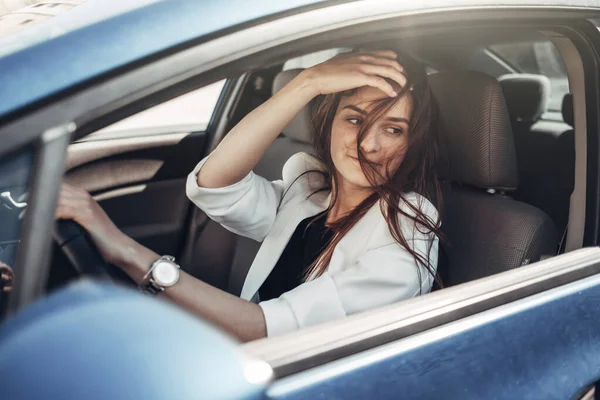 Moda stylowy kierowca dziewczyna w białym garniturze siedzi w samochodzie — Zdjęcie stockowe