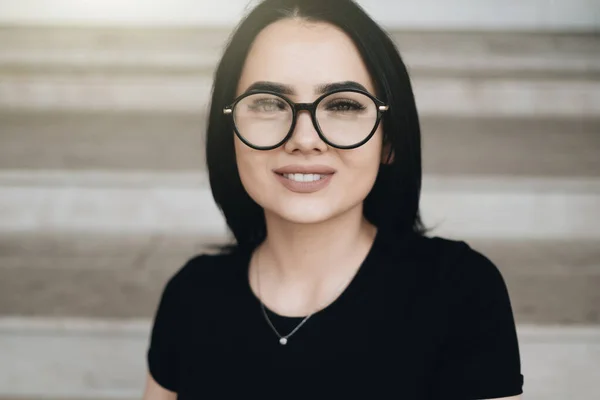 Retrato de Linda chica morena en camiseta negra en gafas —  Fotos de Stock