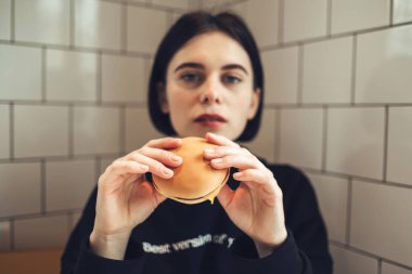 Siyah Kazaklı Güzel Esmer Kız Lezzetli Bir Burger Tutuyor