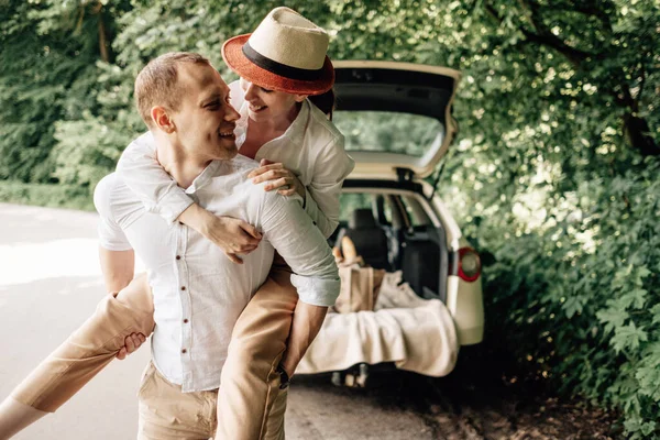 Jeune couple heureux habillé comme dans un t-shirt blanc s'amuser près de la voiture, week-end en dehors de la ville, vacances et voyage Concept — Photo