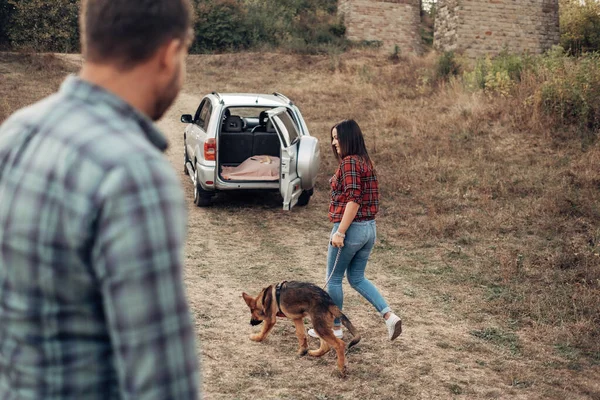 犬と一緒にロードトリップを楽しむ幸せな旅行カップル、休暇のコンセプト、街の外での休日 — ストック写真