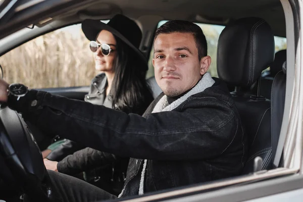검은 스타일 의 옷을 입고 행복 한 여행하는 부부가 여행 차 안에 앉아 휴가를 즐기고 있다 — 스톡 사진