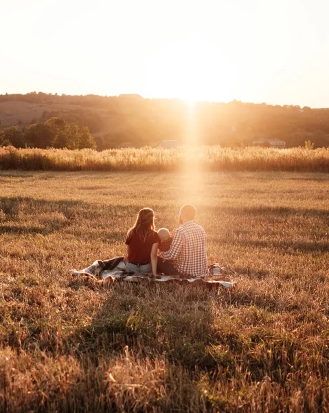 Happy Young Family Mom and Dad with Their Little Son Enjoying Summer Weekend Picnic Outside the City in the Field at Sunny Day Sunset, Vacation Time Concept — Stok Foto
