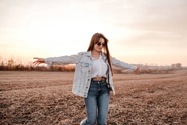 Portré Egy Gyönyörű Stílusos Lány Öltözött Fehér Ing És Jeans Jacket, Szórakozás Kívül A Város A Field Napnyugtakor — Stock Fotó