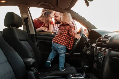 Mutlu Genç Aile Anne ve Baba Oğulları Küçük Sürücüleri Yaz Haftasonu Pikniği Şehrin dışında Sunny Day Sunset, Tatil ve Yolculuk Konsepti 'nde