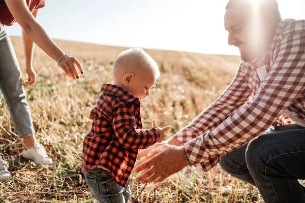 Gelukkig jong gezin mam en pap met hun kleine zoon genieten van de zomer weekend picknick buiten de stad in het veld op zonnige dag zonsondergang, vakantie tijd concept — Stockfoto