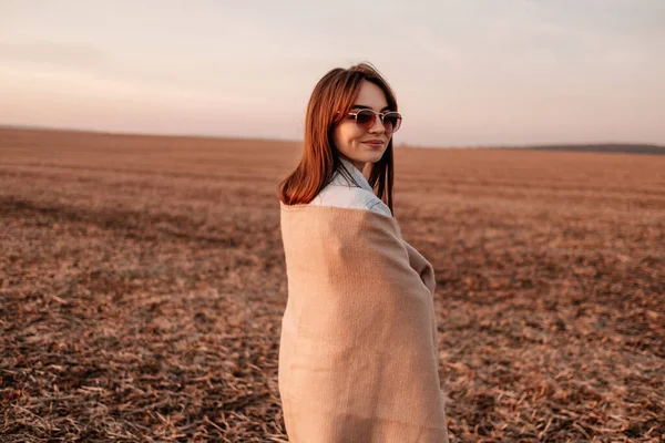 Portret jednej pięknej stylowej dziewczyny ubranej w kurtkę jeansową, bawiącej się dobrze poza miastem na polu o zachodzie słońca — Zdjęcie stockowe