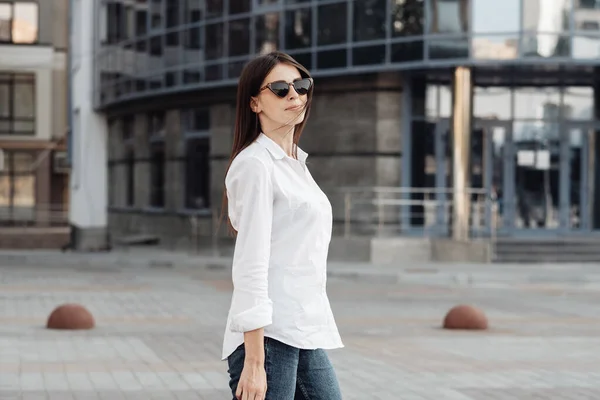 Retrato de una chica de moda vestida con vaqueros y camisa blanca, dama de negocios, concepto de poder de la mujer — Foto de Stock