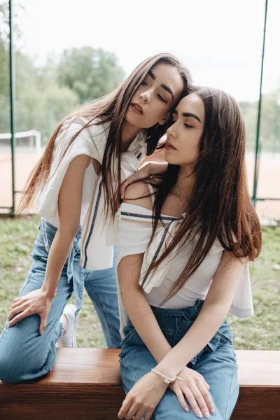 Портрет двох молодих брюнеток сестер близнюків одягнені як у джинси та білі футболки, концепція Best Friends Forever — стокове фото