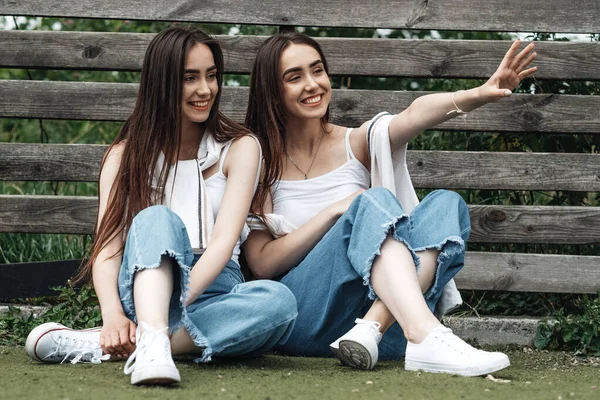 两个穿着牛仔裤和白色T恤衫的年轻布鲁内特孪生姐妹的画像，"永远最好的朋友"概念 — 图库照片