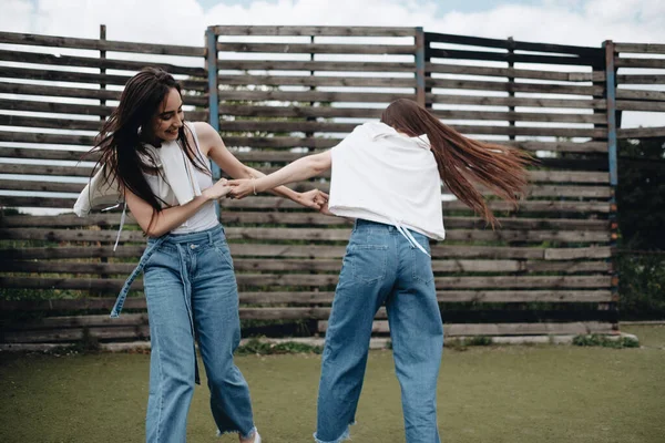 Retrato de duas jovens gêmeas morena irmãs vestidas de jeans e camiseta branca, Melhores amigos sempre conceito — Fotografia de Stock