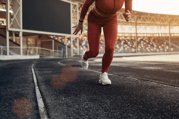 Портрет одной спортивной физкультурницы одетой в одежду спортивной моды, бегающей трусцой на городском стадионе, концепция здорового образа жизни — стоковое фото