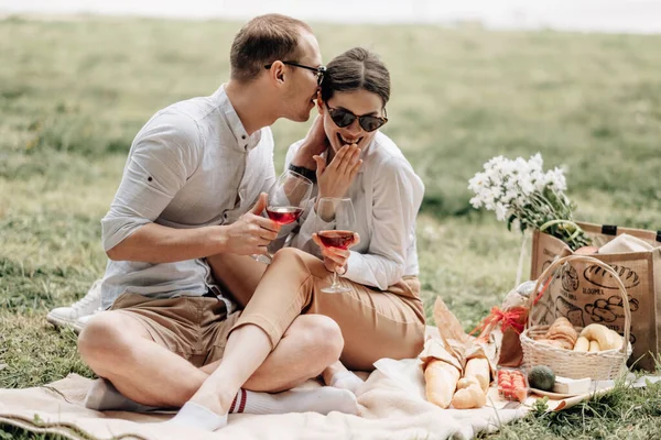 Pareja feliz joven vestida como en camiseta blanca divirtiéndose en el picnic, fin de semana fuera de la ciudad, concepto de vacaciones — Foto de Stock