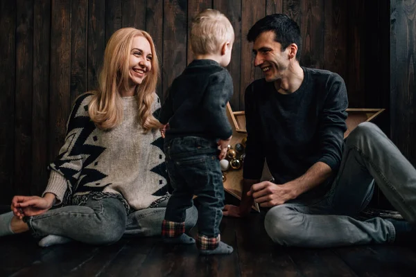 Портрет сім'ї мама тато з маленькою дитиною грає в кімнаті прикрашеній на різдвяну тему — стокове фото