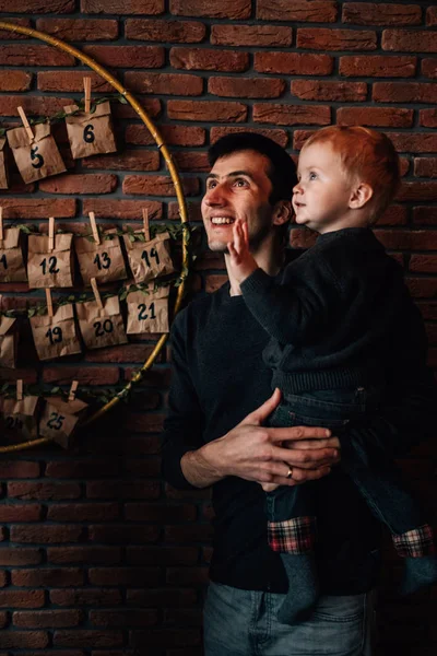 Πορτρέτο ενός μικρού αγοριού με τον μπαμπά του στο δωμάτιο διακοσμημένο με θέμα τα Χριστούγεννα — Φωτογραφία Αρχείου