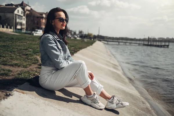 Göl kenarında Güneş Gözlüğü Beyaz Pantolon ve Jeans Ceket Güzel Esmer Kız