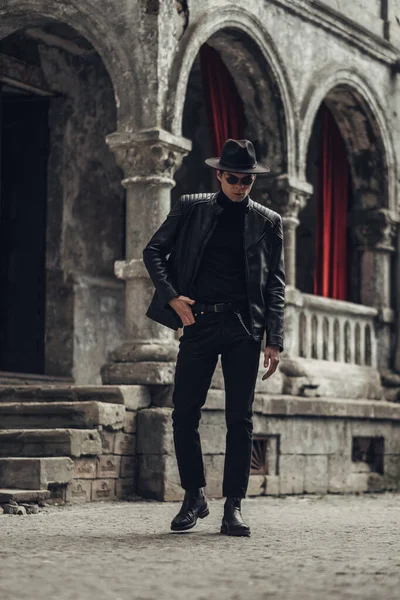 Portrait de jeune homme élégant en veste et chapeau en cuir noir — Photo