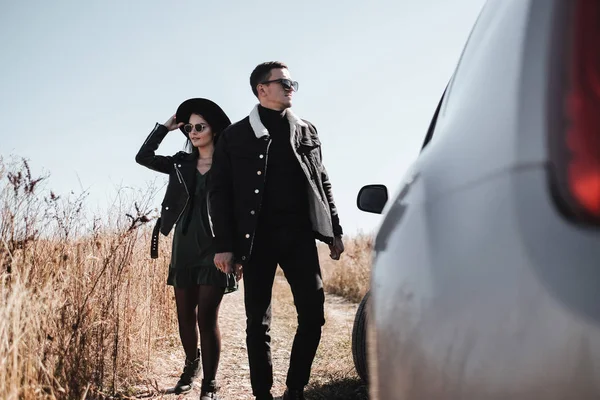 Couple voyageur heureux habillé en noir Vêtements élégants Profitant d'un voyage en voiture sur la route de campagne, concept de vacances — Photo