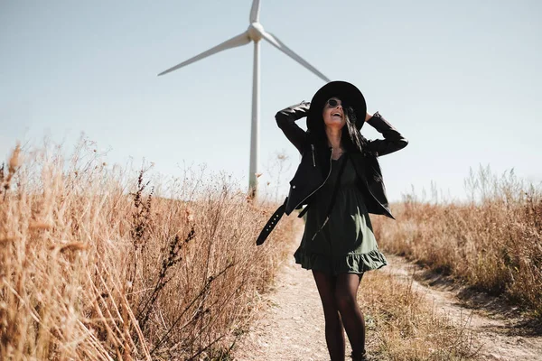 Boldog utazó lány Élvezi a kirándulás a terepen Road elektromos szél turbina áramfejlesztő a háttérben — Stock Fotó