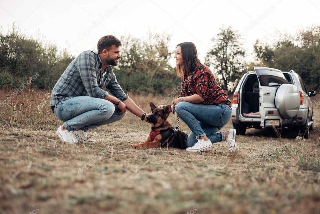 Happy Traveling Couple Together Enjoying Road Trip with their Dog, Vacation Concept, Holidays Outside the City