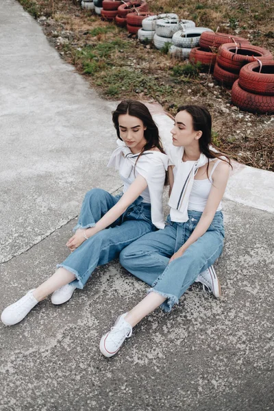Ritratto di due giovani gemelle brune vestite allo stesso modo in jeans e maglietta bianca, Best Friends Forever Concept — Foto Stock