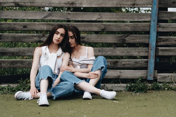 Retrato de duas jovens gêmeas morena irmãs vestidas de jeans e camiseta branca, Melhores amigos sempre conceito — Fotografia de Stock