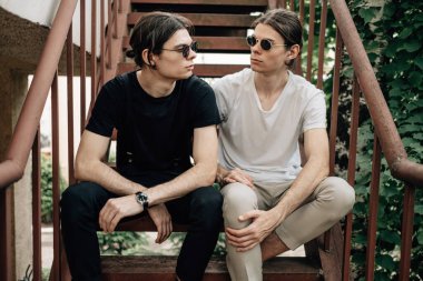 Merdivenlerde oturan iki şık ikiz kardeş.