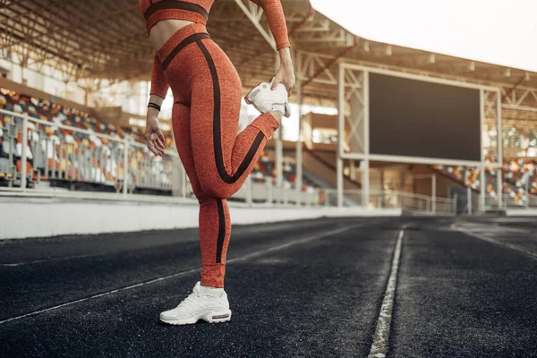 Retrato de una chica deportiva vestida con ropa deportiva haciendo estiramientos Ejercicio y entrenamiento en el estadio de la ciudad, concepto de estilo de vida saludable — Foto de Stock