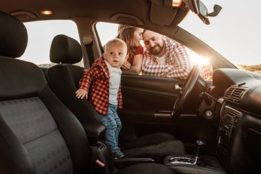 Mutlu Genç Aile Anne ve Baba Oğulları Küçük Sürücüleri Yaz Haftasonu Pikniği Şehrin dışında Sunny Day Sunset, Tatil ve Yolculuk Konsepti 'nde