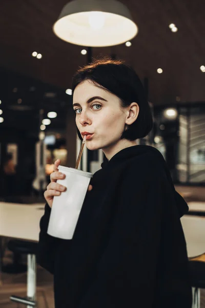 Mooi Brunette meisje in zwart Pullover houdt een drankje — Stockfoto