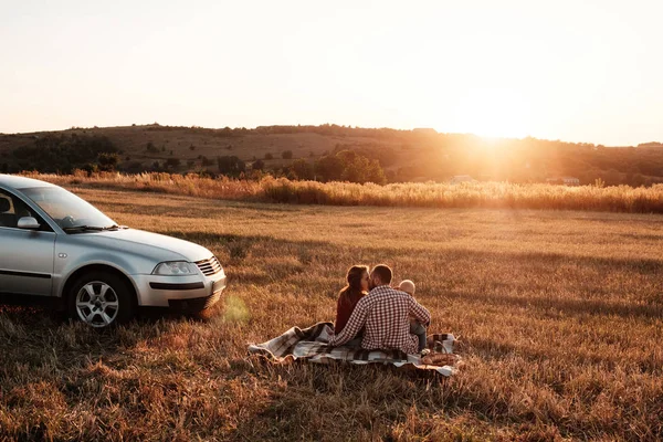 Happy Young Family Mom and Dad with Their Little Son Enjoying Summer Weekend Picnic on the Car Outside the Field at Sunny Day Sunset, Vacation and Road Trip Concept — Stok Foto