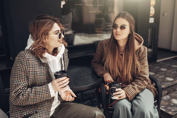 Портрет двух девушек моды, лучших друзей на открытом воздухе, кофе-брейк ланч в солнечный день — стоковое фото