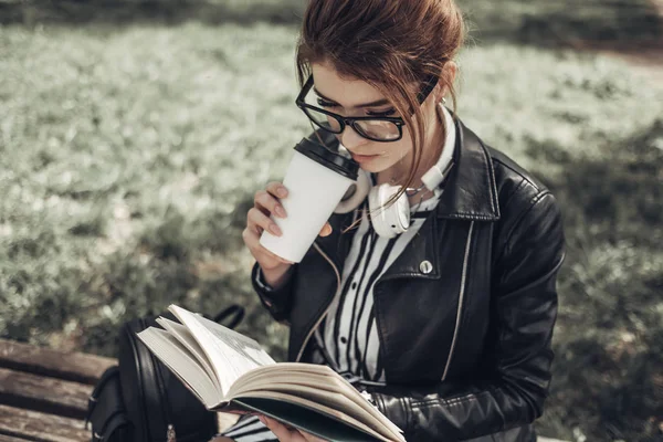 Outdoor Summer Portrait of Young Beautiful Girl in Black Leather Jacket Leads Livro no Parque — Fotografia de Stock