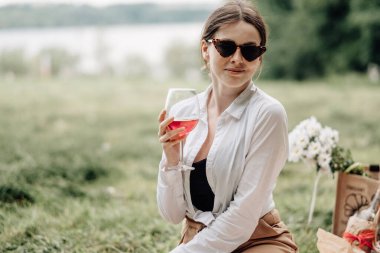 Beyaz tişörtlü genç şık kız piknikte eğleniyor, haftasonu şehir dışında, tatil konsepti.