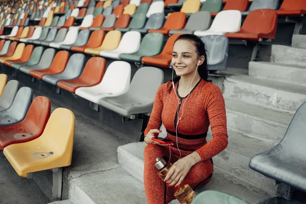 Retrato de una chica deportiva vestida con ropa deportiva haciendo ejercicio y entrenamiento en el estadio de la ciudad, concepto de estilo de vida saludable —  Fotos de Stock
