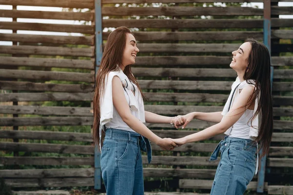 Portretul a două tinere surori gemene brunete îmbrăcate ca în blugi și tricou alb, cel mai bun concept de prieteni pentru totdeauna — Fotografie, imagine de stoc