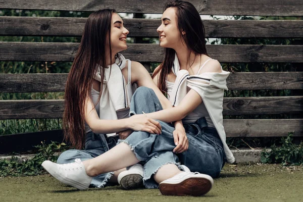 Портрет двух юных Брюнеток-близнецов, одетых одинаково в джинсы и белую футболку, "Лучшие друзья навсегда" — стоковое фото