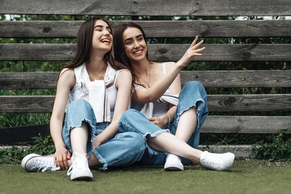 Портрет двух юных Брюнеток-близнецов, одетых одинаково в джинсы и белую футболку, "Лучшие друзья навсегда" — стоковое фото