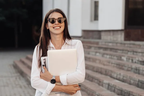 Portret jednej modnej dziewczyny ubranej w dżinsy i białą koszulę z laptopem, niezależny strzelec, Business Lady, kobieta Power Concept — Zdjęcie stockowe