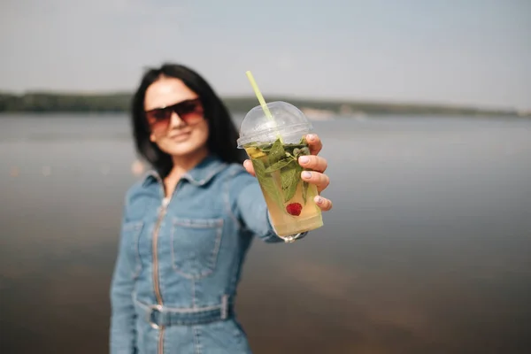 One Beautiful Brunette Girl Dressed in Jeans Overalls Drinks Cocktail — Stock Photo, Image
