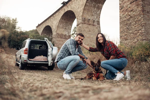 Szczęśliwa para podróżująca razem Ciesząca się wycieczką z psem, Koncepcja wakacji, Wakacje poza miastem — Zdjęcie stockowe