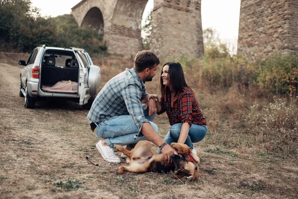 Happy Traveling Couple Together Enjoying Road Trip with their Dog, Vacation Concept, Holidays Outside the City